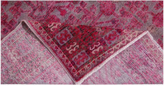 An antique handwoven Chinese Khotan rug featuring an intricate pink pomegranate pattern.