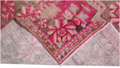 A vintage handwoven Khotan rug featuring an intricate pomegranate pattern in vibrant pink tones.