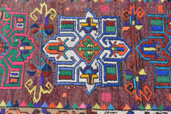 A vintage Kurdish Herki runner featuring a geometric tribal pattern in vibrant neon colors.