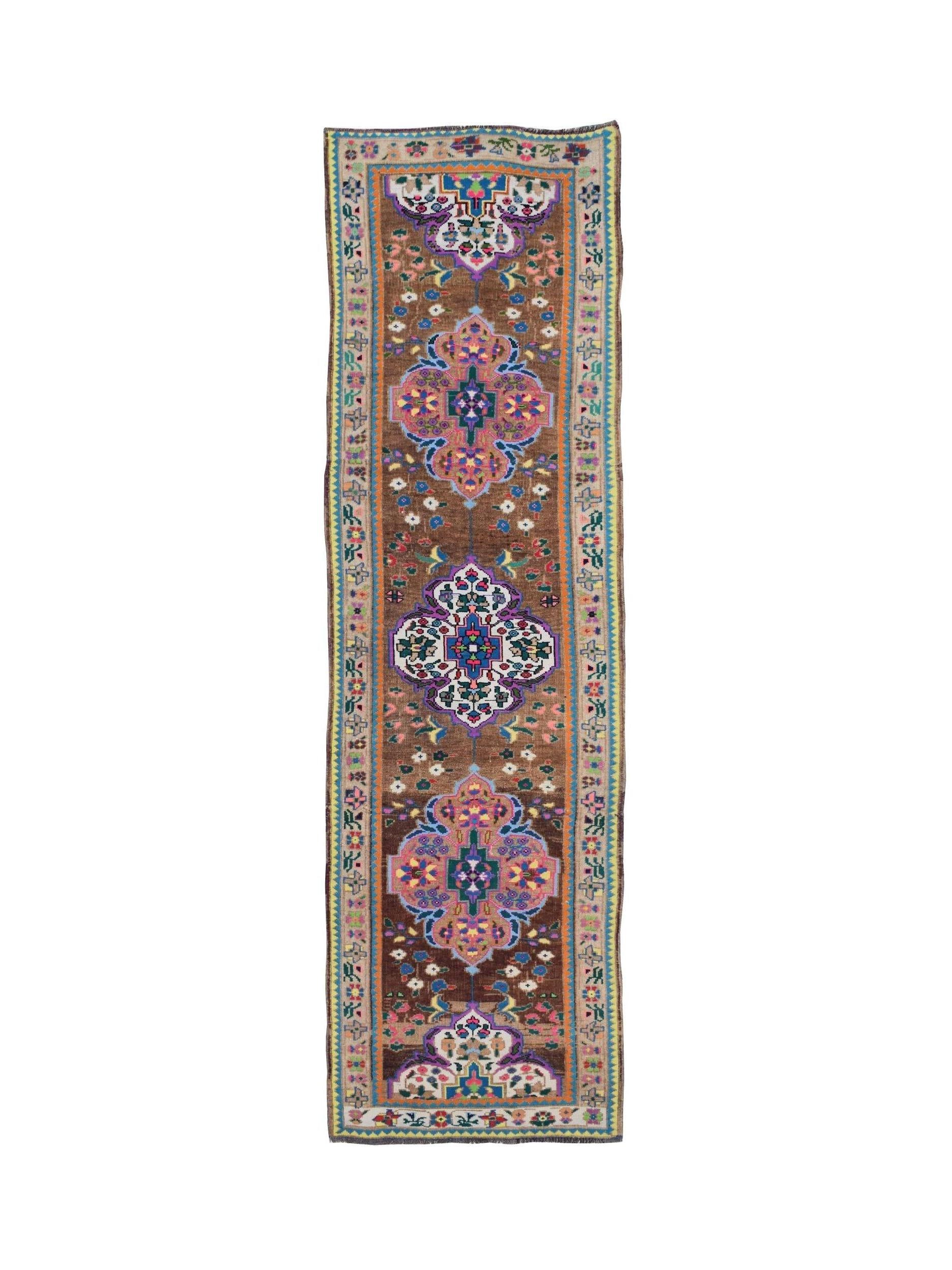 A vintage handmade Kurdish Herki runner featuring tribal motifs in a vibrant, multi-colored palette.