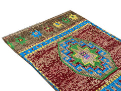 A vintage Kurdish Herki runner featuring a geometric medallion in red, blue, green, and yellow.