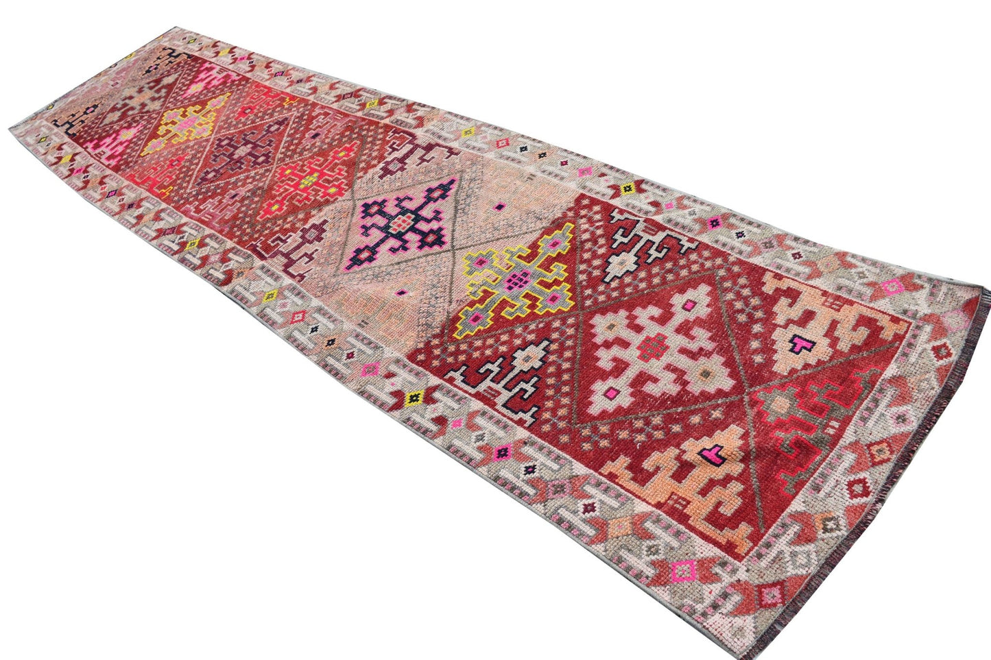 Vintage Kurdish Herki runner with tribal motifs in red, pink, and yellow.