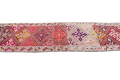 A vintage Kurdish Herki runner featuring geometric tribal motifs in vibrant, multicolored wool.