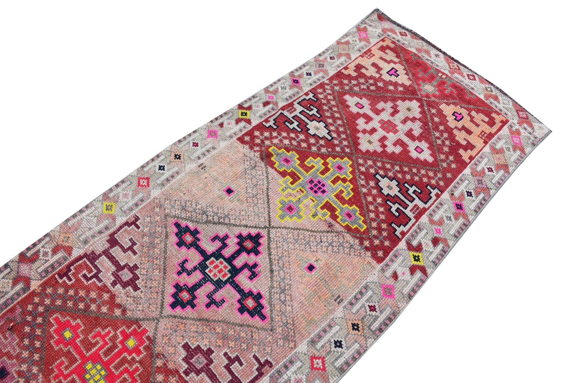 Vintage Kurdish Herki runner with geometric tribal patterns in red, pink, and grey.