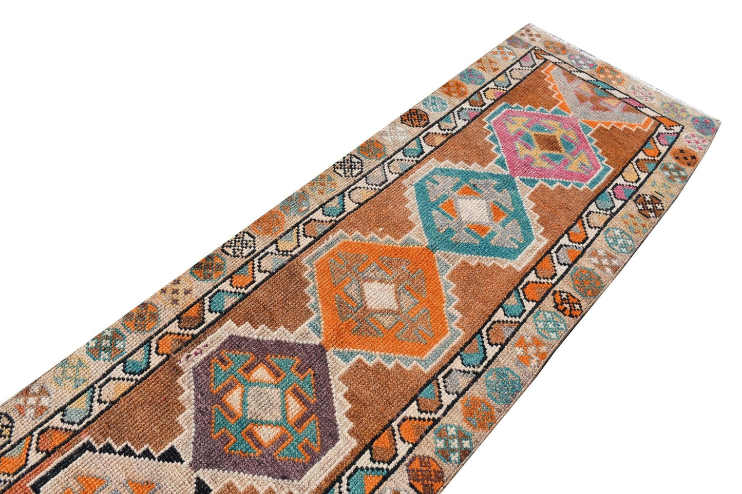 Vintage Kurdish Herki runner with tribal motifs in brown, orange, pink, and teal.