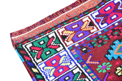 A vintage Kurdish Herki runner featuring vibrant tribal motifs in wool and nylon.
