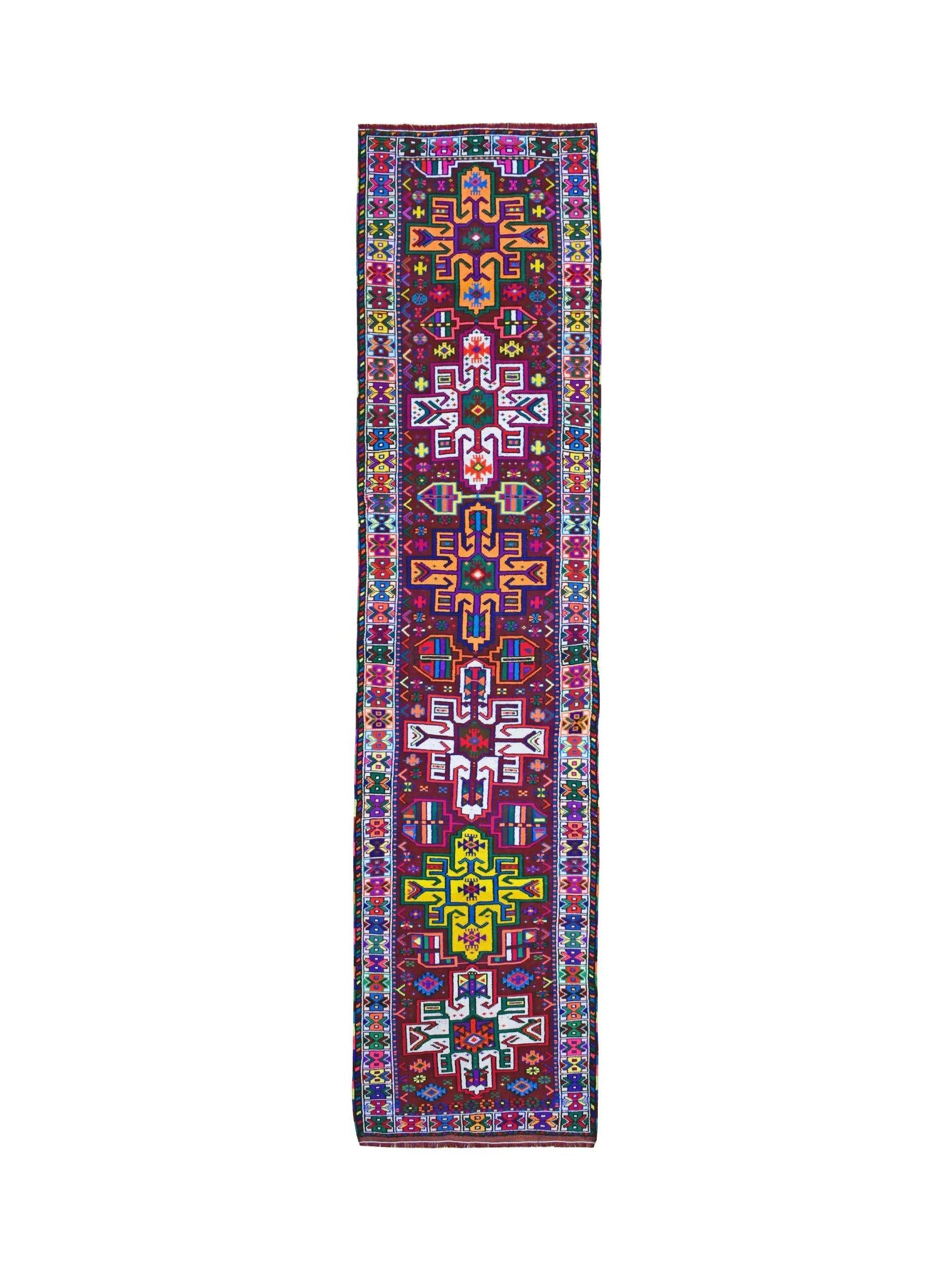 A vintage Kurdish Herki runner featuring vibrant tribal motifs on a dark wool background.
