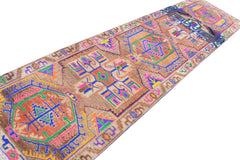 A vintage Kurdish Herki runner featuring tribal motifs in vibrant neon colors on a brown wool base.