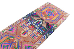 A vintage Kurdish Herki runner featuring tribal motifs in vibrant neon colors on a wool base.