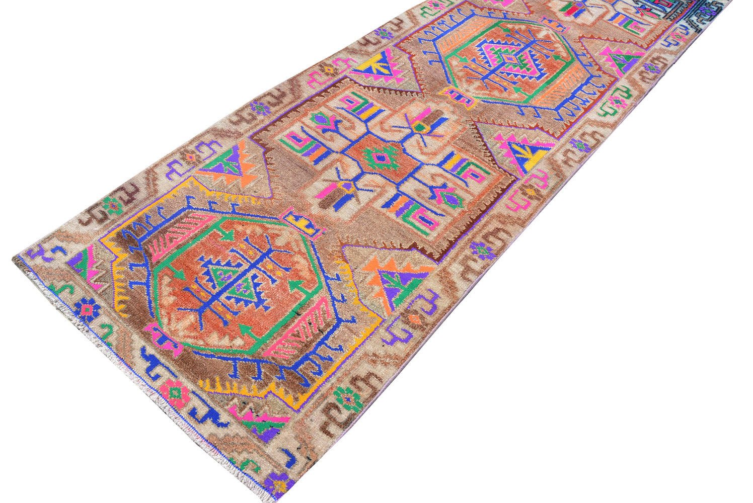 A vintage Kurdish Herki runner featuring tribal motifs in vibrant neon colors on a brown wool base.