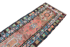 A vintage Kurdish Herki runner featuring tribal motifs in vibrant neon colors on a brown wool base.