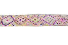 A vintage Kurdish Herki runner featuring tribal diamond motifs in neon colors on a wool base.