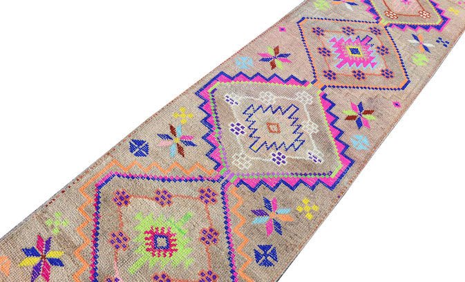 A vintage Kurdish Herki runner featuring tribal geometric motifs in vibrant neon colors.