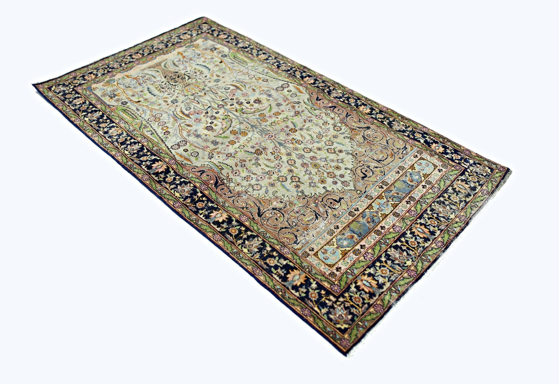A vintage handmade Persian prayer rug featuring an intricate floral pattern on a light field.