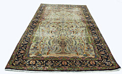 A vintage handmade Persian prayer rug featuring a central vase and floral tree design.