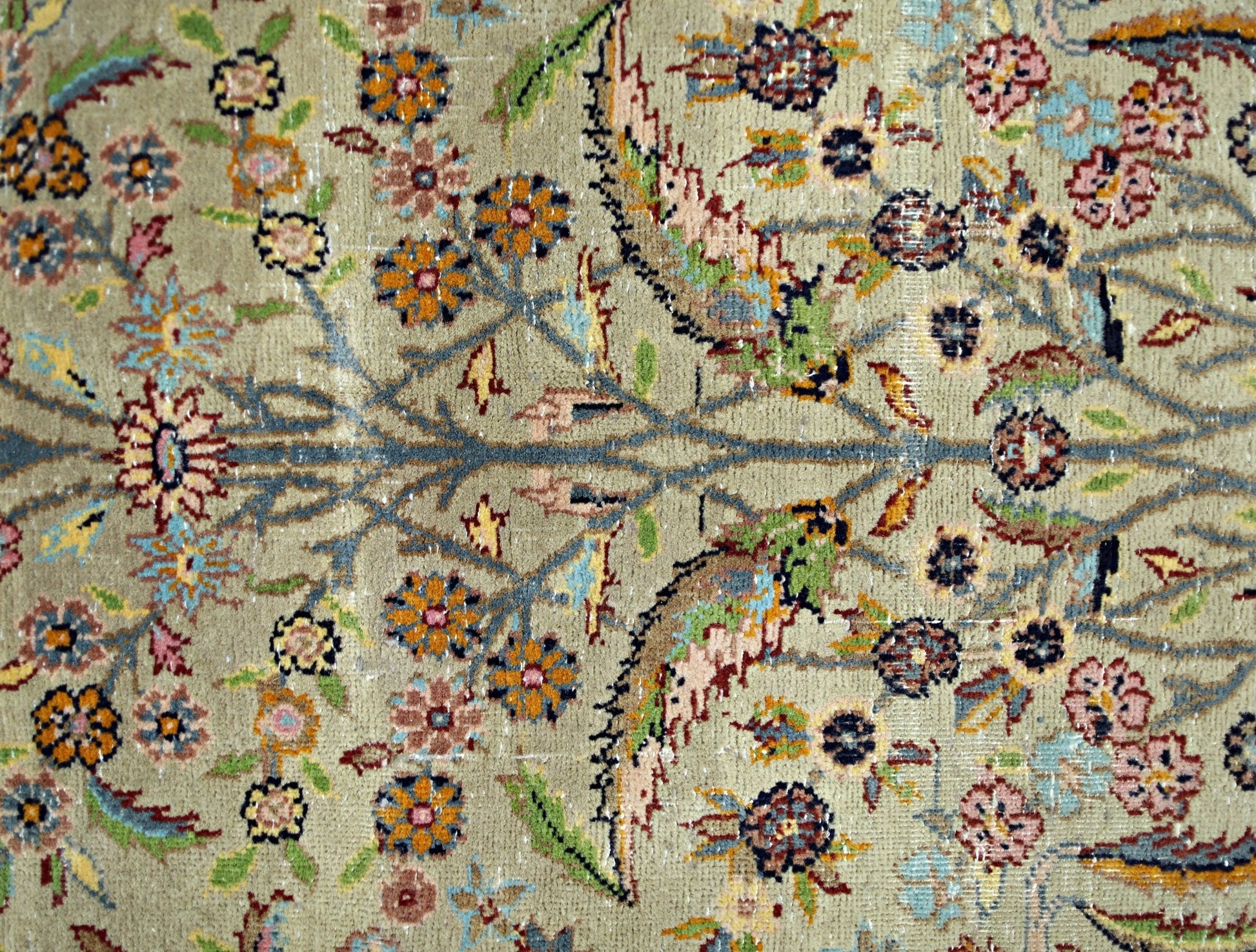 A vintage Persian prayer rug featuring a detailed floral pattern in muted tones on a wool pile.