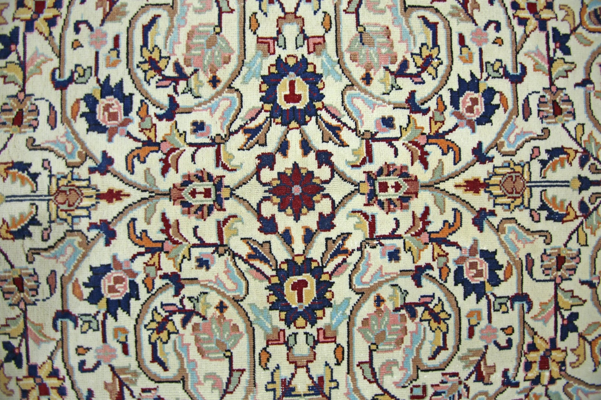 A vintage Pakistani rug featuring a symmetrical floral pattern in blue, red, and cream tones.