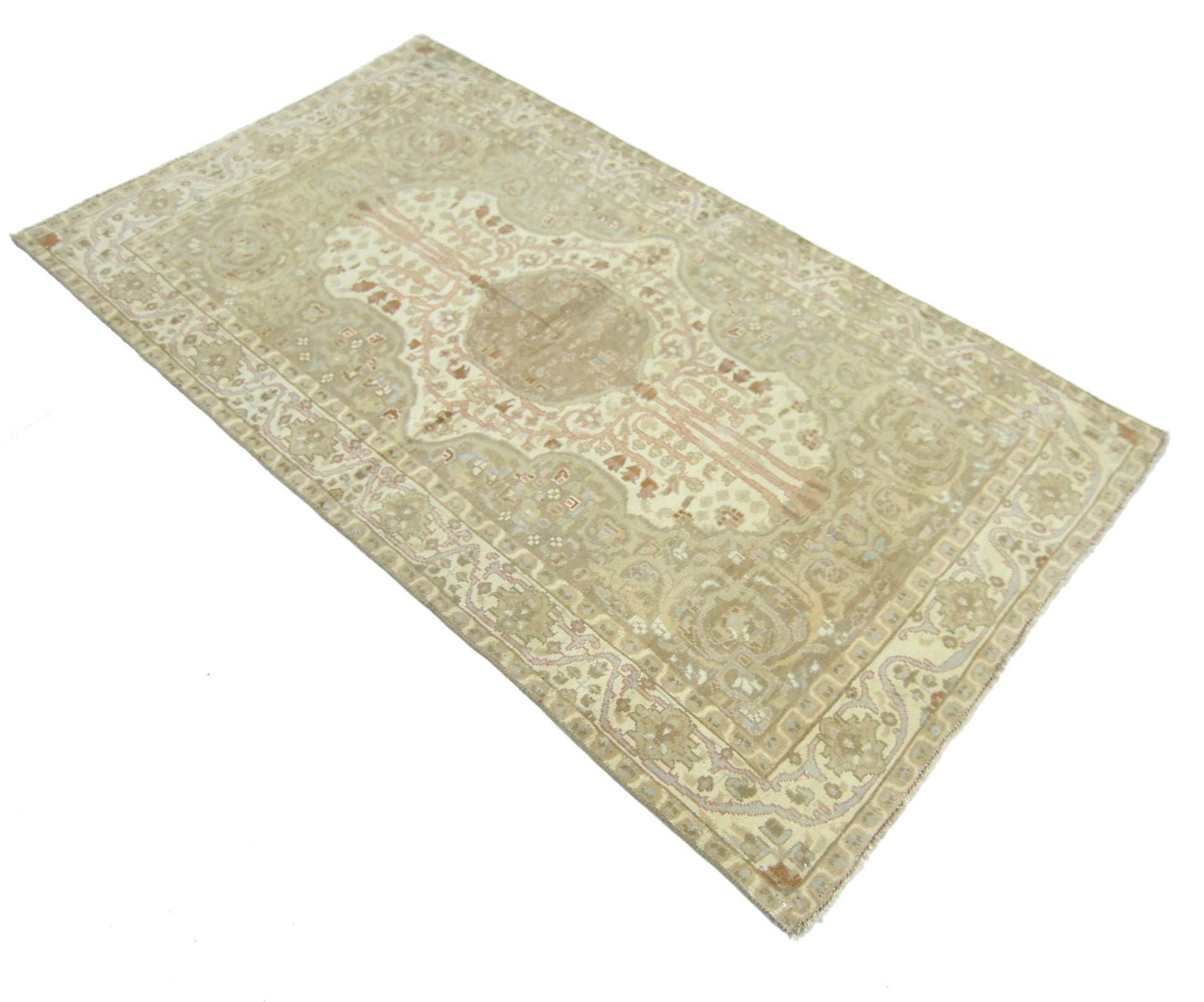 A vintage Pakistani rug featuring a traditional medallion pattern in muted beige and cream tones.