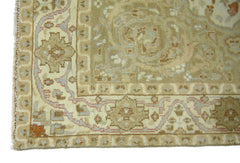 A vintage Pakistani rug featuring a traditional geometric pattern in muted beige and soft blue tones.