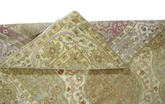 A folded vintage Pakistani rug featuring a traditional geometric pattern in muted earth tones.