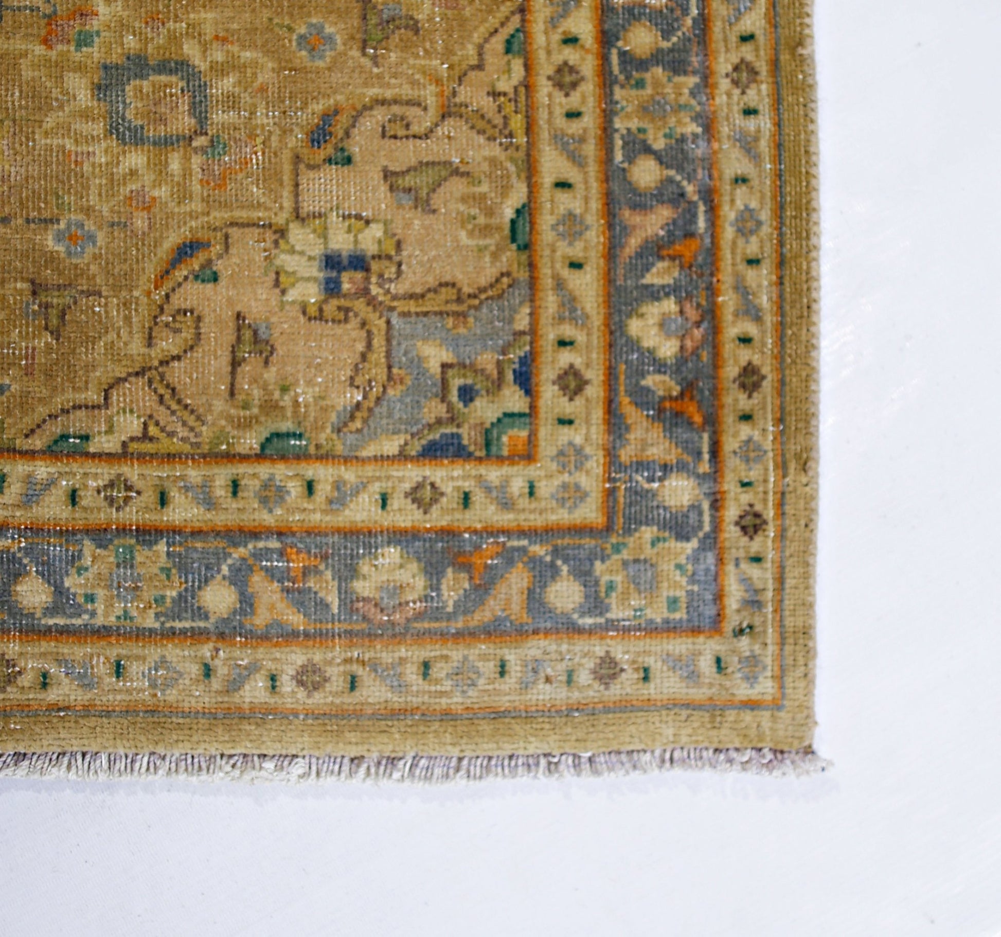 A vintage Pakistani rug featuring a tan field with intricate floral patterns and a detailed border.