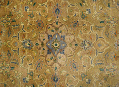 A vintage rug featuring an intricate floral medallion design in soft, muted earth tones.