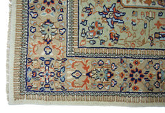 A vintage Pakistani rug featuring intricate floral patterns in blue, orange, and beige tones.