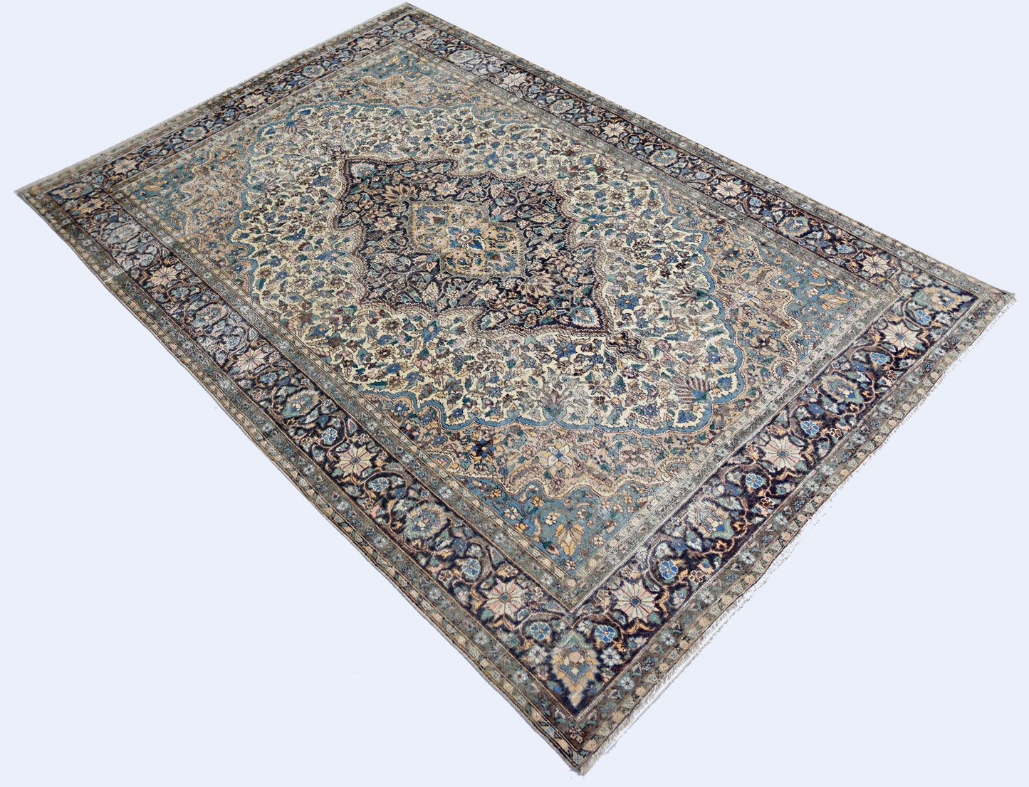A vintage Pakistani rug featuring an intricate floral medallion design in blue and cream tones.