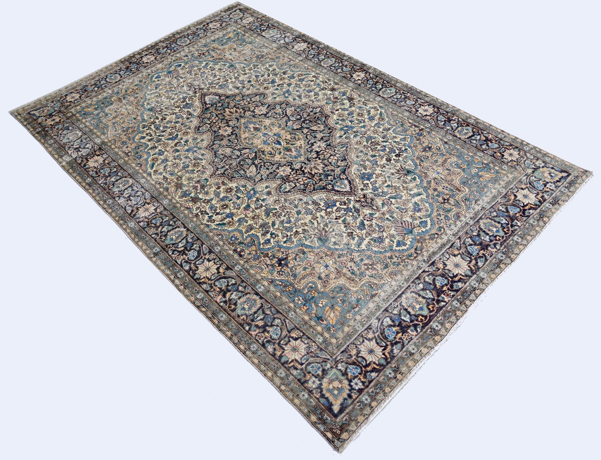 A vintage Pakistani rug featuring an intricate floral medallion design in blue and cream tones.