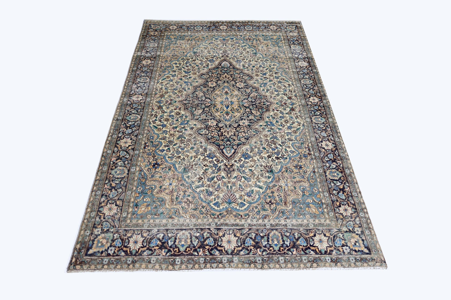 A vintage Pakistani rug featuring an intricate central medallion and floral patterns in blue and cream.