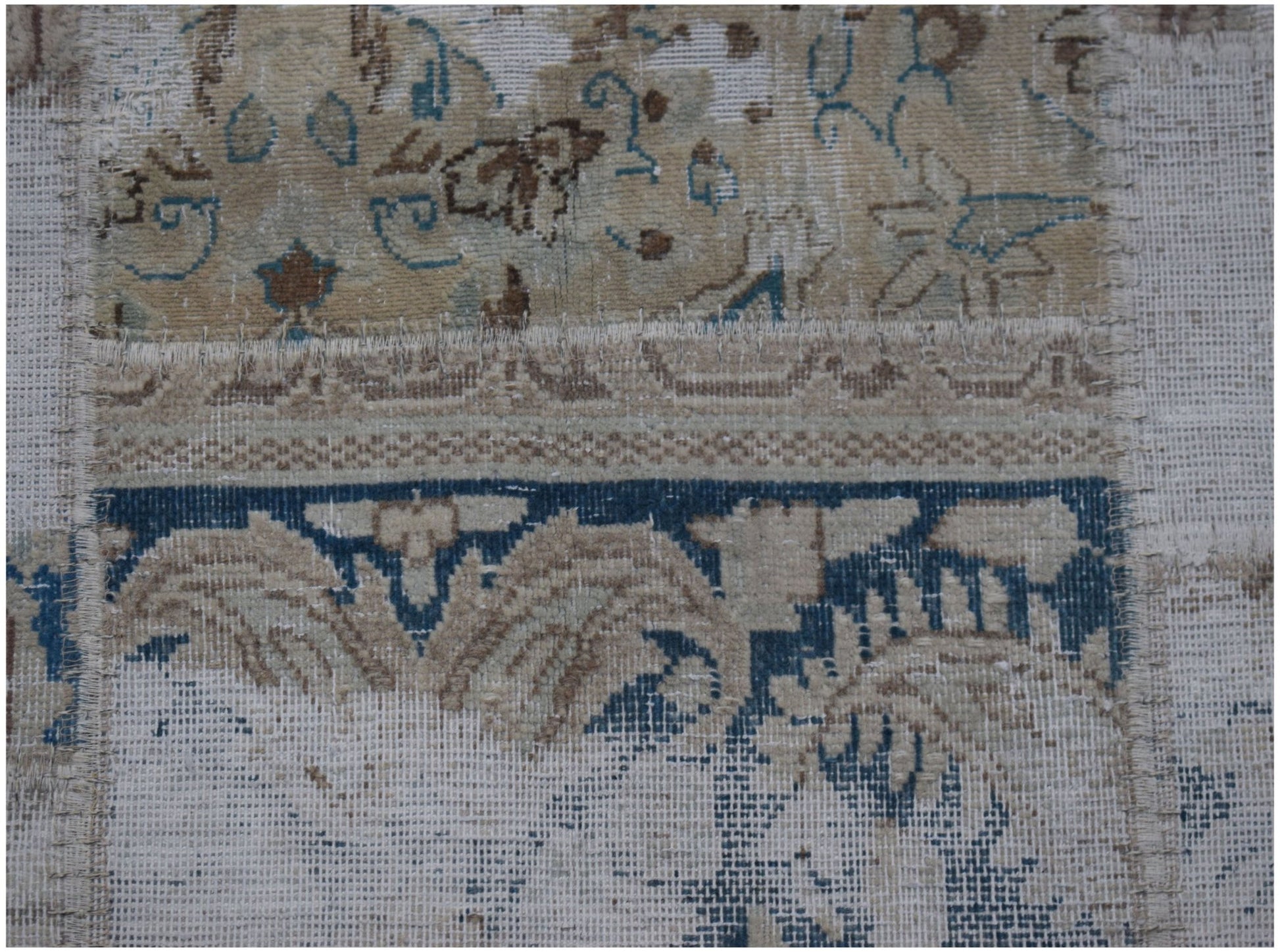A handmade vintage patchwork rug featuring stitched sections of wool in blue and beige tones.