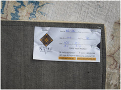 The underside of a handmade vintage patchwork rug showing a product label from Najaf Rugs.