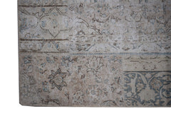 A handmade vintage patchwork rug featuring a faded floral pattern in shades of beige and blue.
