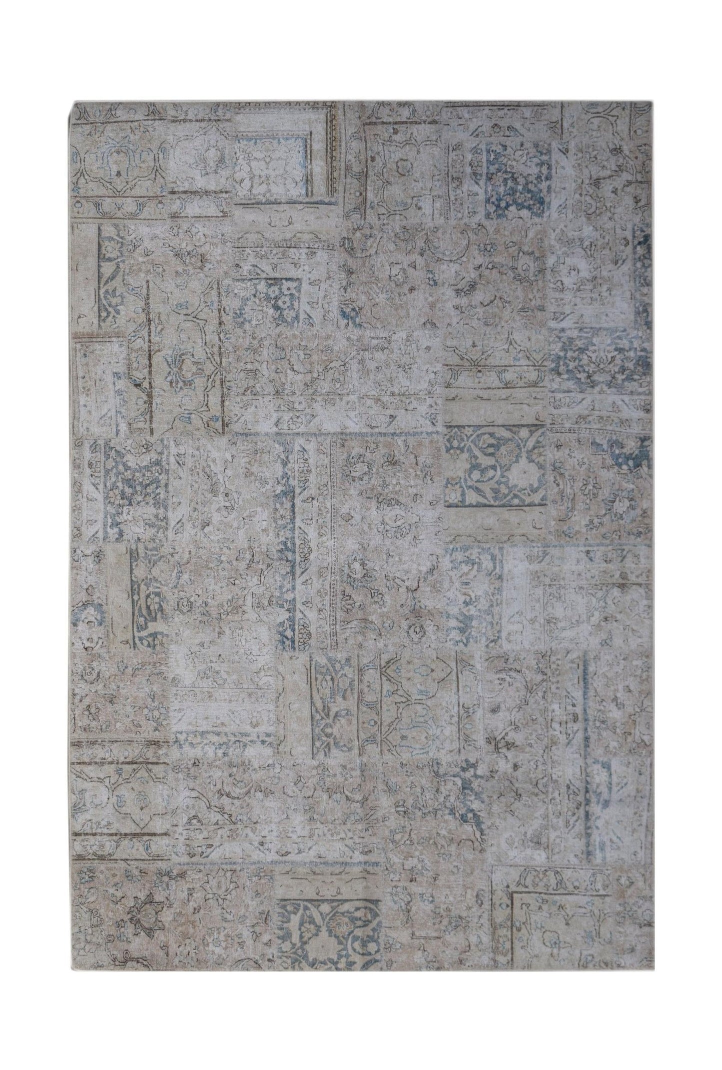 A handmade wool patchwork rug featuring a faded vintage design in shades of beige and blue.
