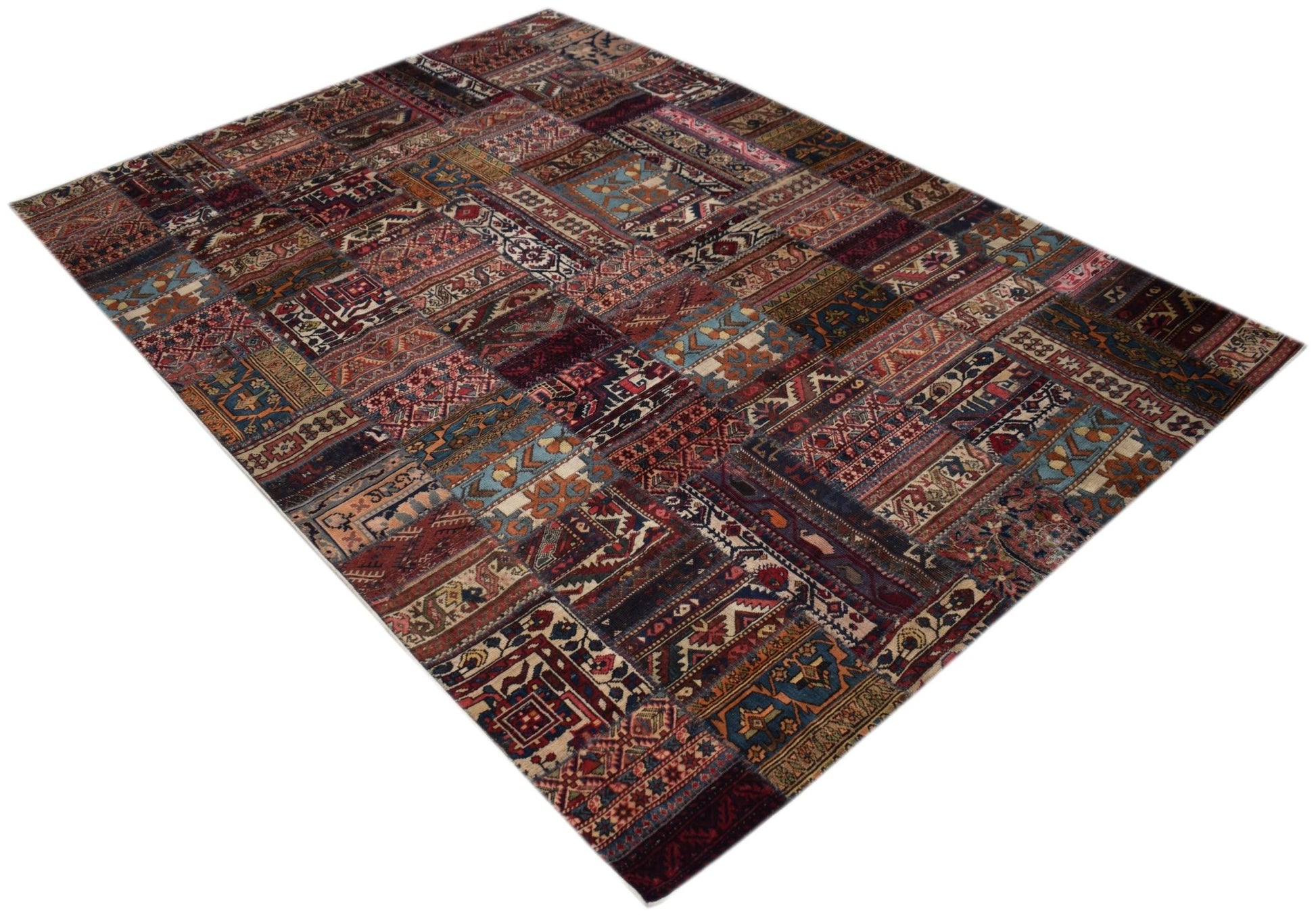 A handmade vintage patchwork rug featuring a variety of colorful, intricate traditional patterns.