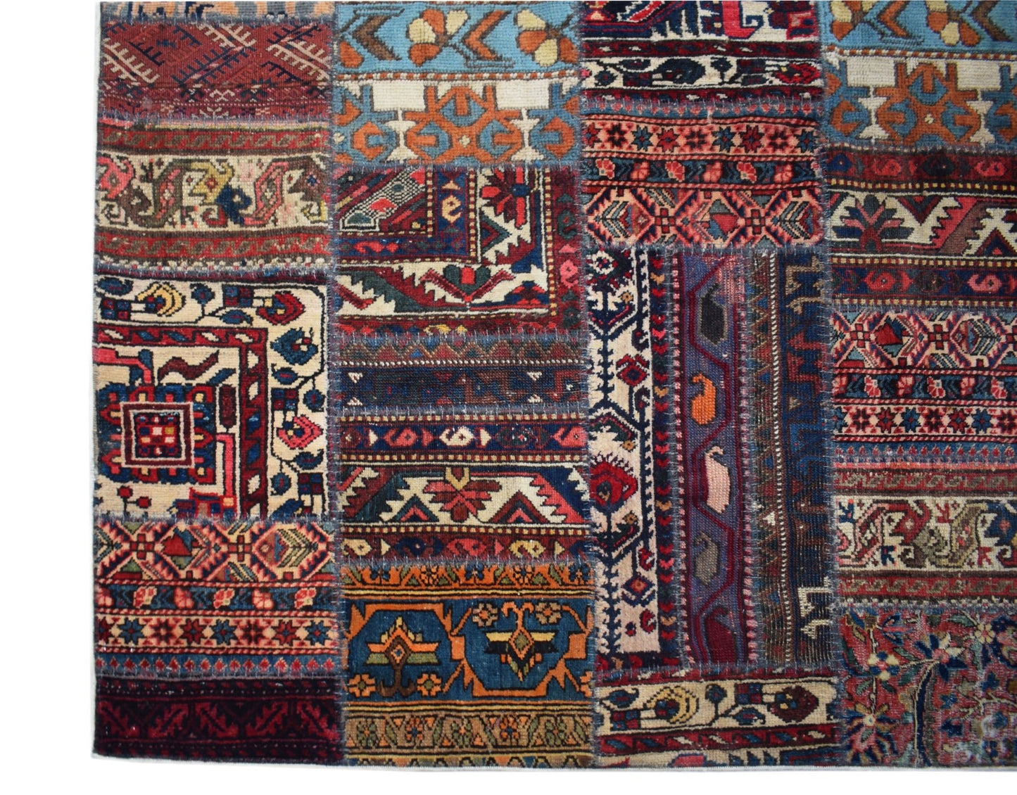 A handmade vintage patchwork rug featuring a colorful array of traditional Afghan wool patterns.