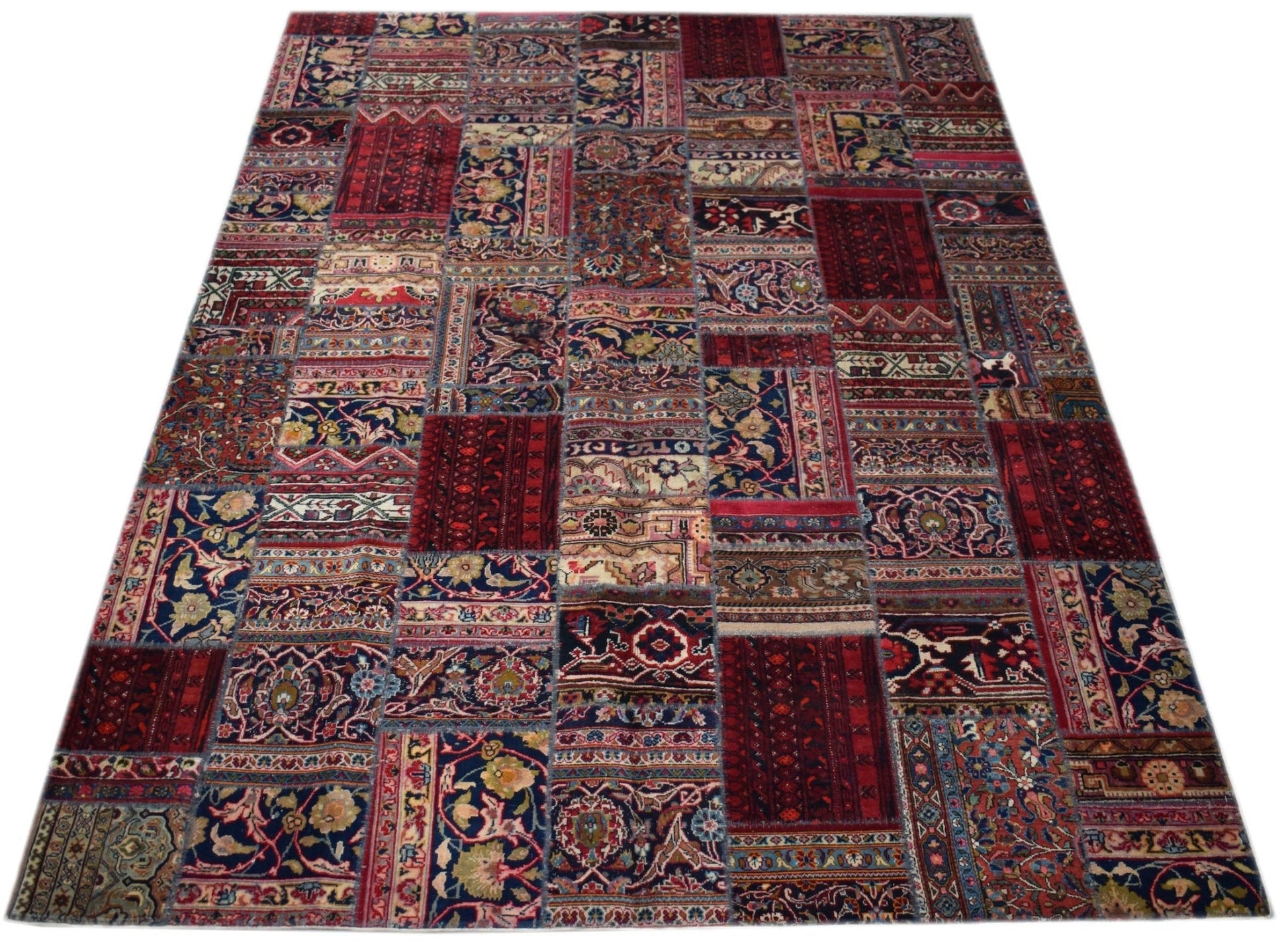 A handmade patchwork rug featuring a variety of vintage-style floral and geometric patterns.