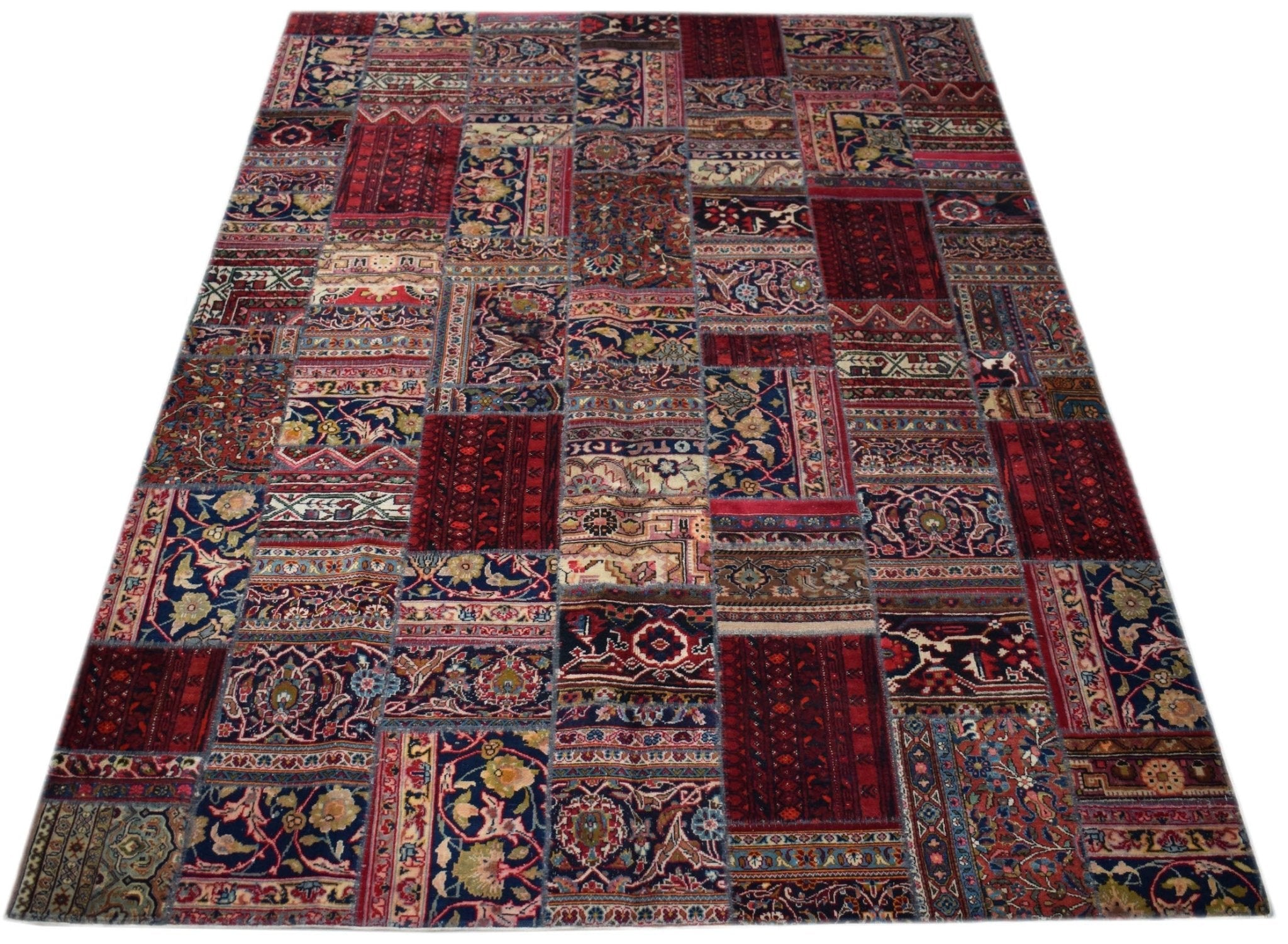 A handmade patchwork rug featuring a variety of vintage-style floral and geometric patterns.