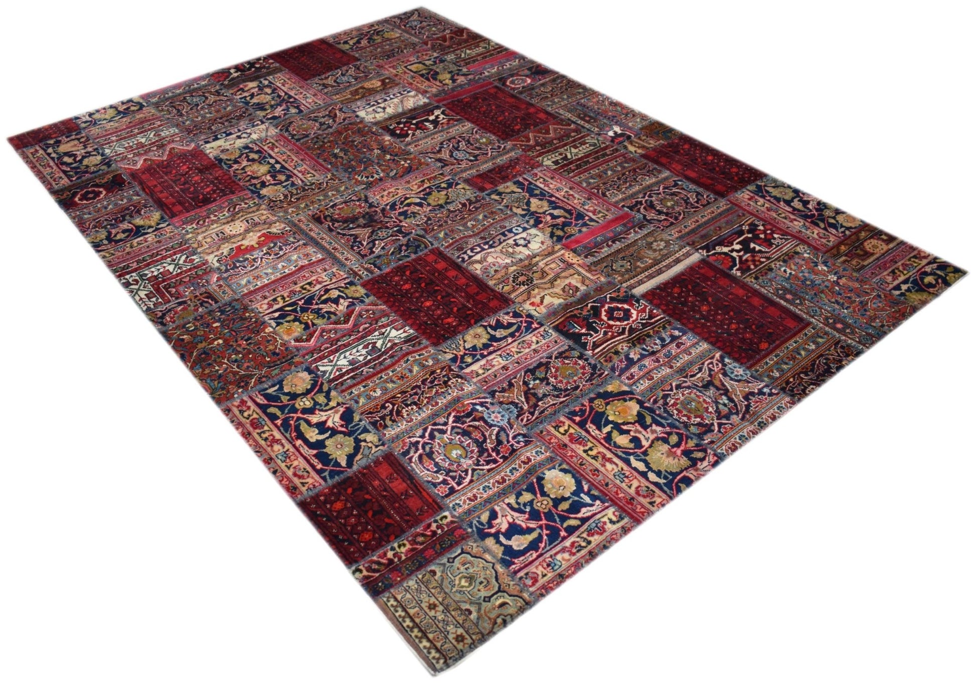 A handmade patchwork rug featuring a variety of vintage-style floral and geometric patterns.