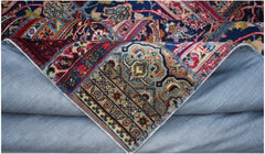 A vintage patchwork rug with intricate floral patterns in blue, red, and beige wool on cotton.