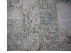 A handmade vintage patchwork rug featuring faded floral patterns in shades of blue and beige.