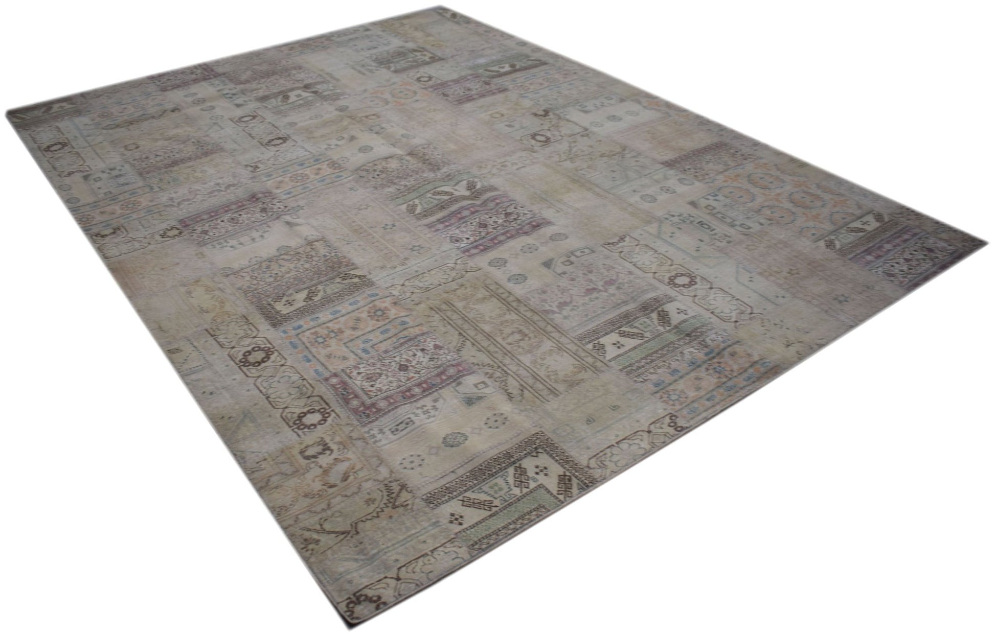 A rectangular handmade vintage patchwork rug featuring faded patterns in neutral earth tones.