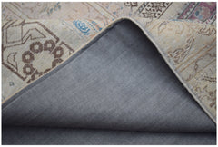 A corner of a handmade vintage patchwork rug showing its patterned wool top and cotton backing.