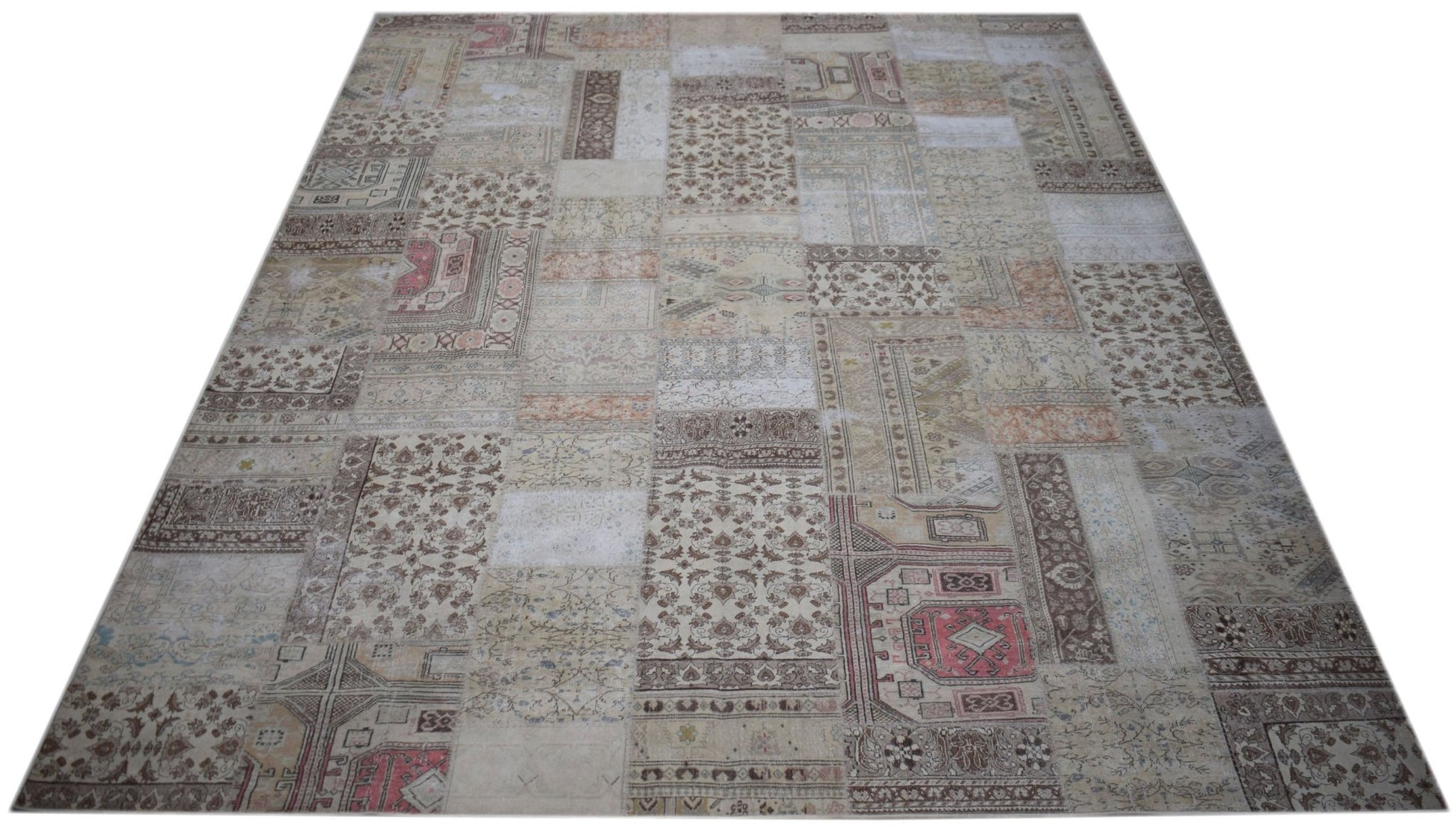 A handmade vintage patchwork rug featuring a neutral color palette with intricate floral patterns.