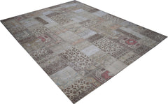 A handmade vintage patchwork rug featuring a neutral color palette with faded floral patterns.