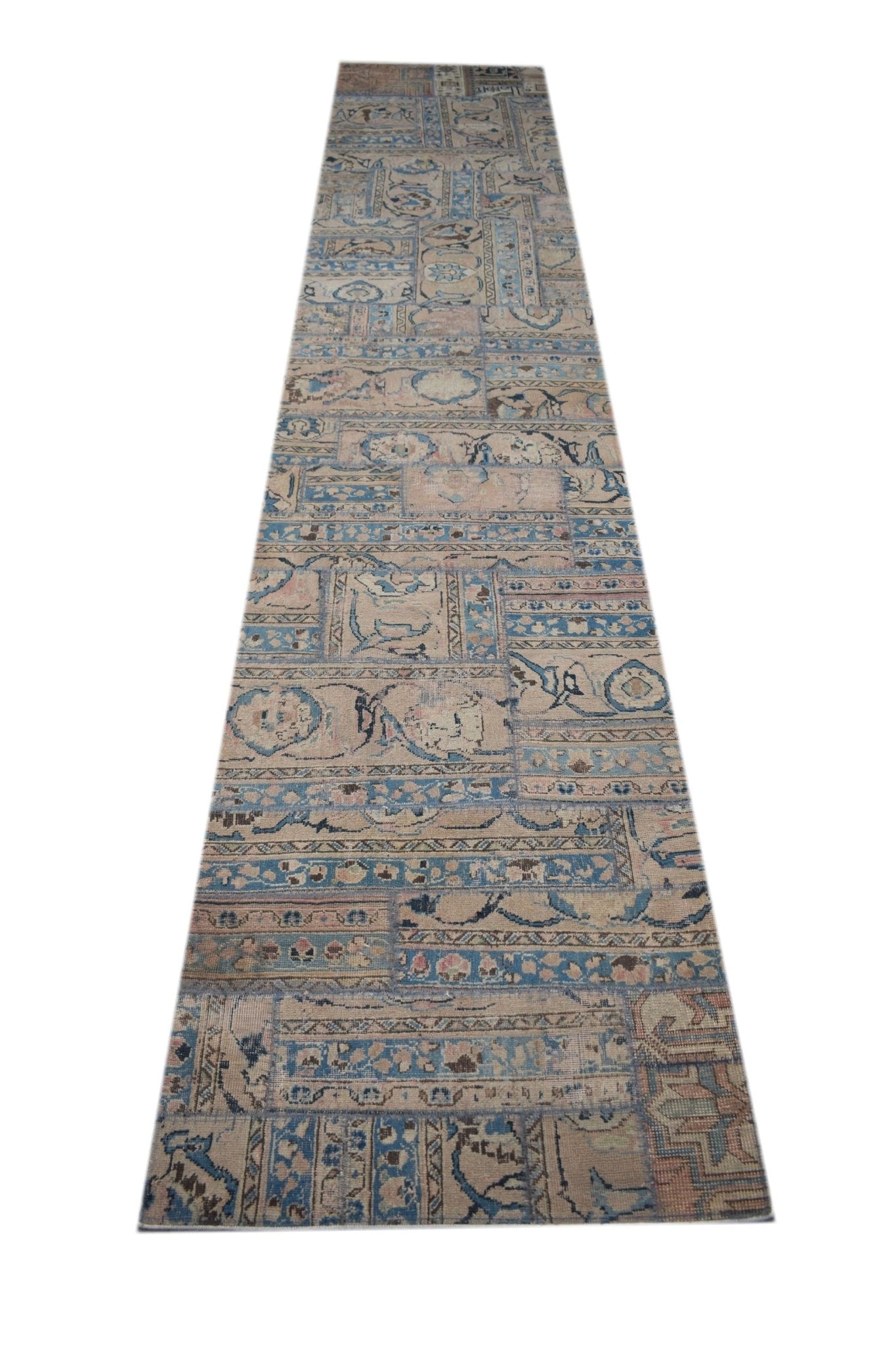 A handmade vintage patchwork runner rug featuring a faded blue and beige geometric pattern.