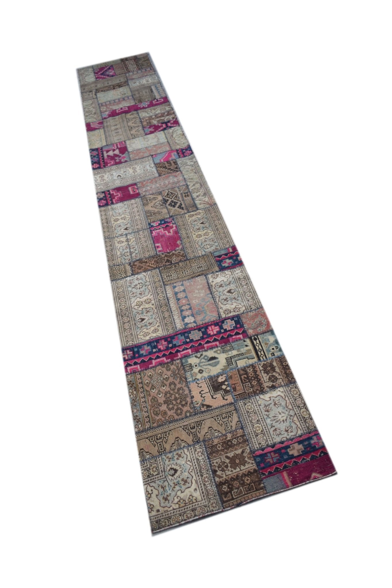 A long, handmade vintage patchwork runner rug featuring a variety of wool patterns in pink and beige.