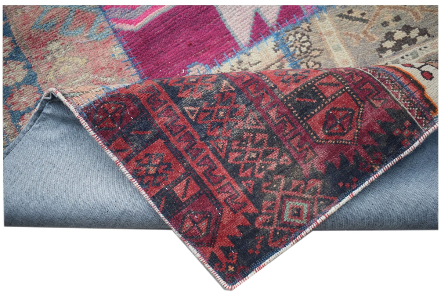 A handmade vintage patchwork runner featuring colorful wool patterns on a cotton backing.