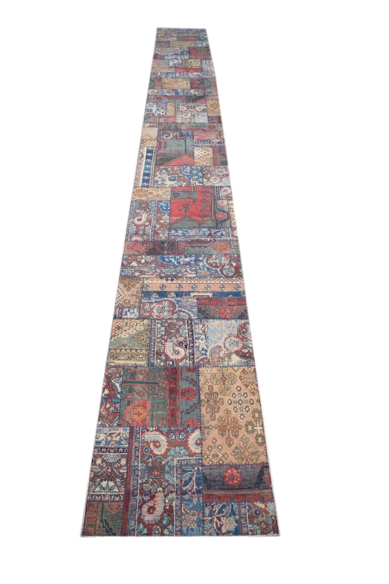 A long, handmade vintage runner rug featuring a colorful patchwork of various traditional patterns.