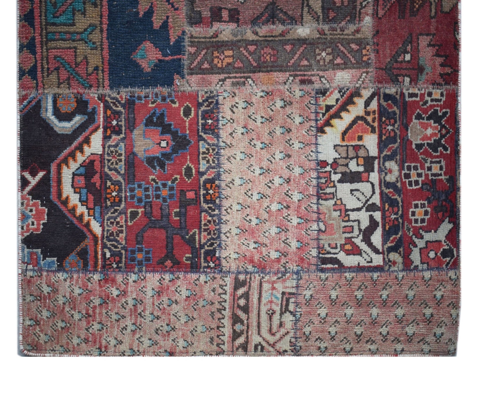 A handmade vintage patchwork runner featuring a variety of colorful wool rug fragments.